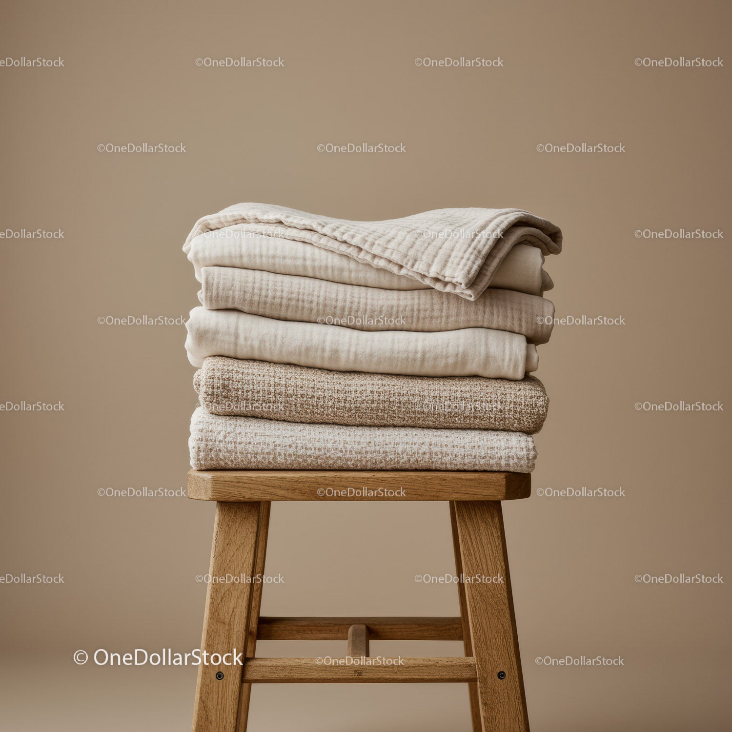 Stack of Soft Beige Textured Blankets on Wooden Stool