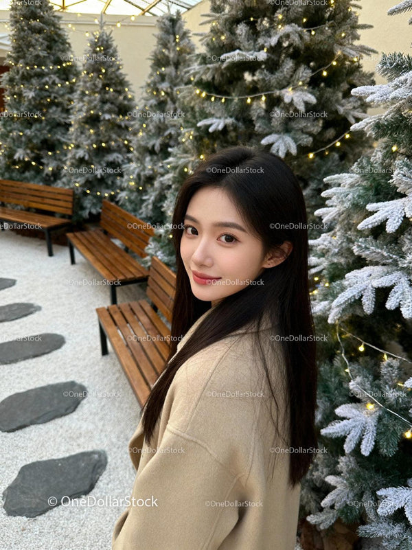 Young woman enjoying festive winter garden with lights