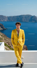Man in yellow suit standing by sea cliffs
