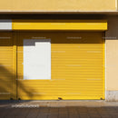 Closed yellow storefront with blank white poster panel