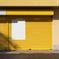 Closed yellow storefront with blank white poster panel