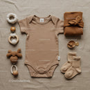 Neutral baby outfit with accessories on linen fabric