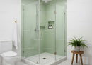 Modern glass shower with green tiles and fresh decor