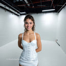 Happy Young Woman Wearing White Dress in Studio Setting