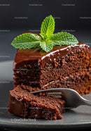 Slice of moist chocolate cake with glossy ganache topping