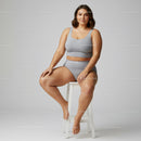 Plus Size Woman in Gray Sportswear Sitting Confidently on a Stool