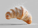 Golden Croissant with Powdered Sugar on White Background
