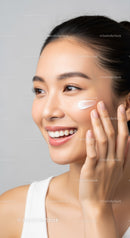 Close-up of a smiling woman applying facial moisturizer for beauty care