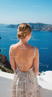 Woman in Floral Dress Enjoying Ocean View from Balcony