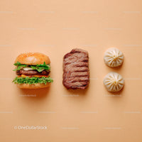 Gourmet Burger with Lettuce and Tomato Next to Grilled Steak and Dumpling