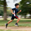Young boy running energetically through park trail