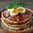 Banana Pancakes with Honey and Fresh Mint on a Wooden Plate