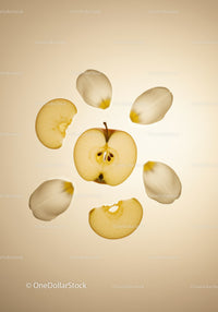 Sliced apple and delicate white flower petals arranged