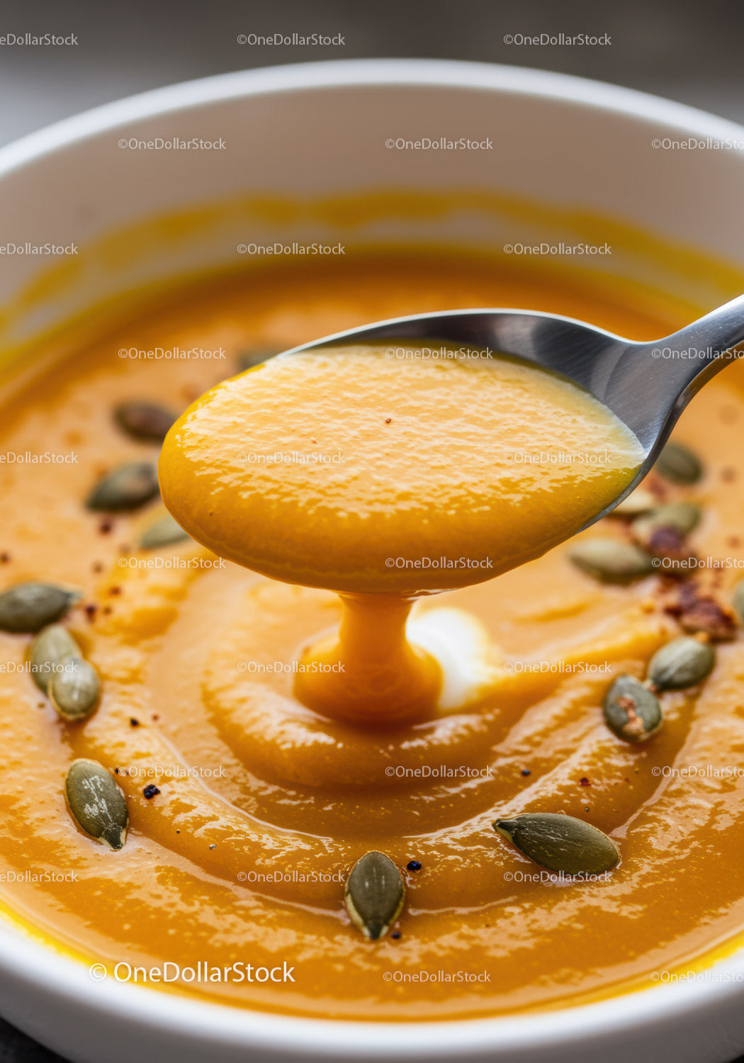 Creamy pumpkin soup with toasted seeds close up