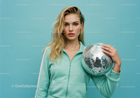 Young Woman in Mint Green Tracksuit Holding Disco Ball in Studio