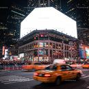 Busy New York City intersection with yellow taxis at night