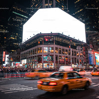 Busy New York City intersection with yellow taxis at night