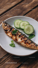 Grilled Fish with Sliced Cucumber and Fresh Mint on White Plate