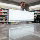 Smiling pharmacist behind illuminated counter in pharmacy