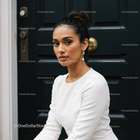 Elegant woman in white dress sitting by dark door