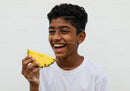 Young Boy Enjoying Juicy Pineapple Over White Background