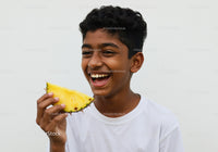 Young Boy Enjoying Juicy Pineapple Over White Background