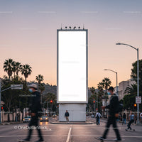 Urban street scene with large blank billboard at sunset