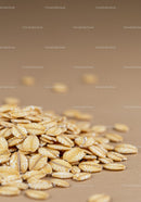 Close up of whole grain rolled oats on beige surface