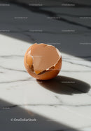 Cracked brown eggshell on marble kitchen surface