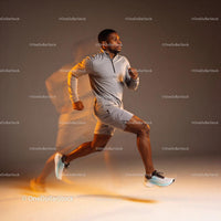 Active man running fast in gray sportswear indoors