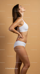 Elegant Young Woman in White Sportswear Posing on Studio Background