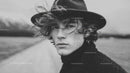 Black and White Portrait of Young Man with Curly Hair and Wide-Brim Hat