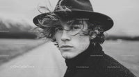 Black and White Portrait of Young Man with Curly Hair and Wide-Brim Hat