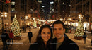 Smiling couple enjoying festive city street at night