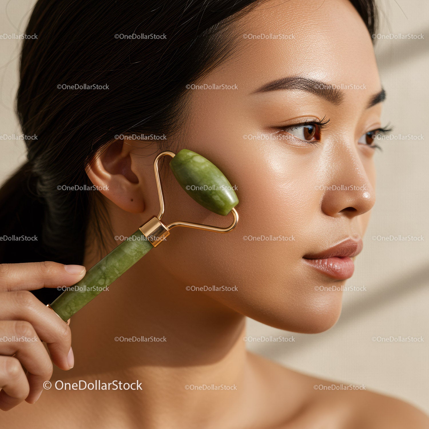 Close-up of a woman using jade roller for skincare treatment