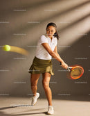 Focused female tennis player hitting a backhand shot