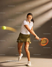 Focused female tennis player hitting a backhand shot