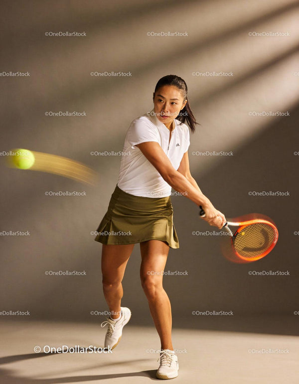 Focused female tennis player hitting a backhand shot