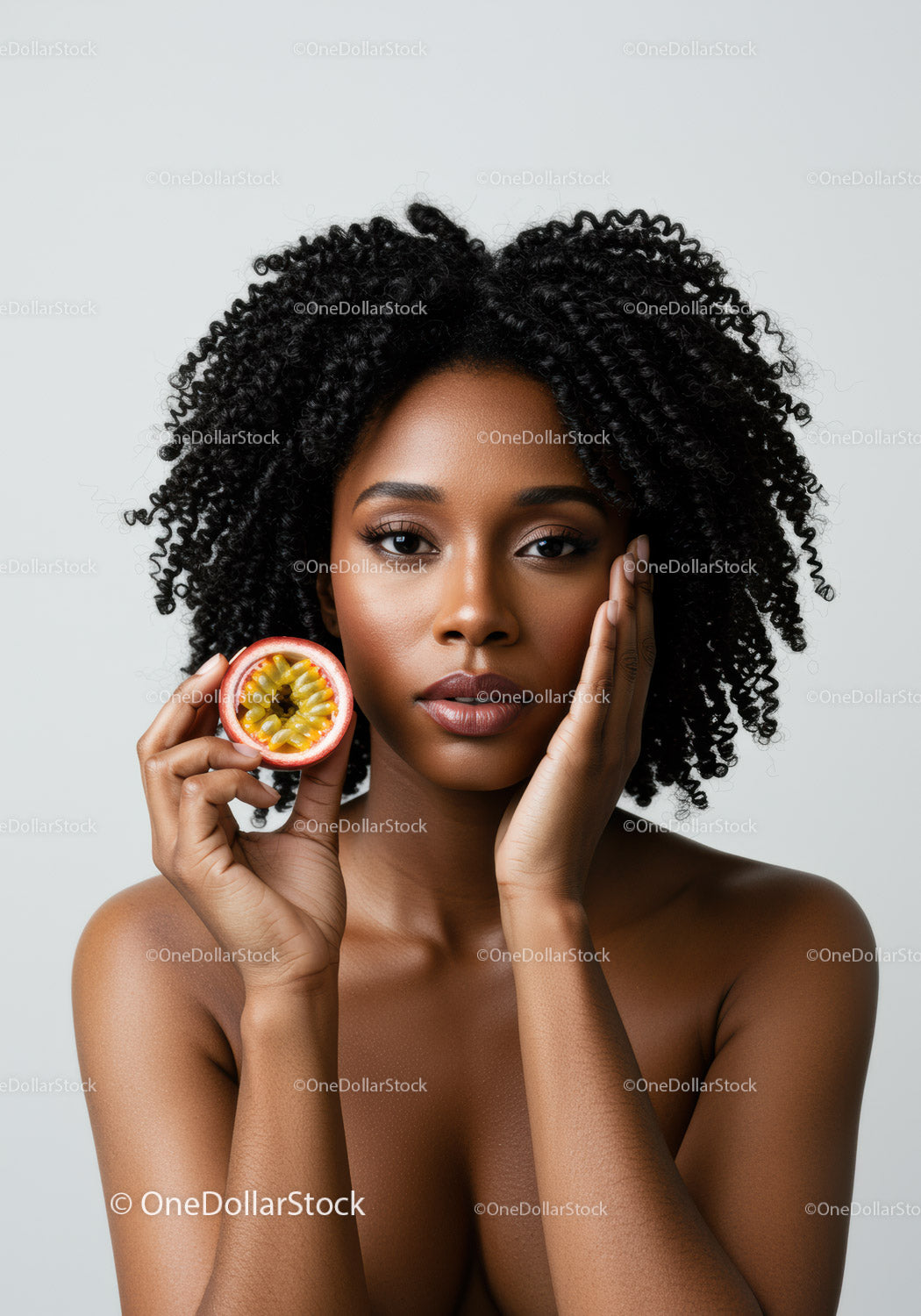 Portrait of an African American Woman with Curly Hair Holding Passion Fruit