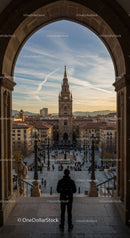 View of a Gothic Style Cathedral Tower in a Busy City Square at Sunset