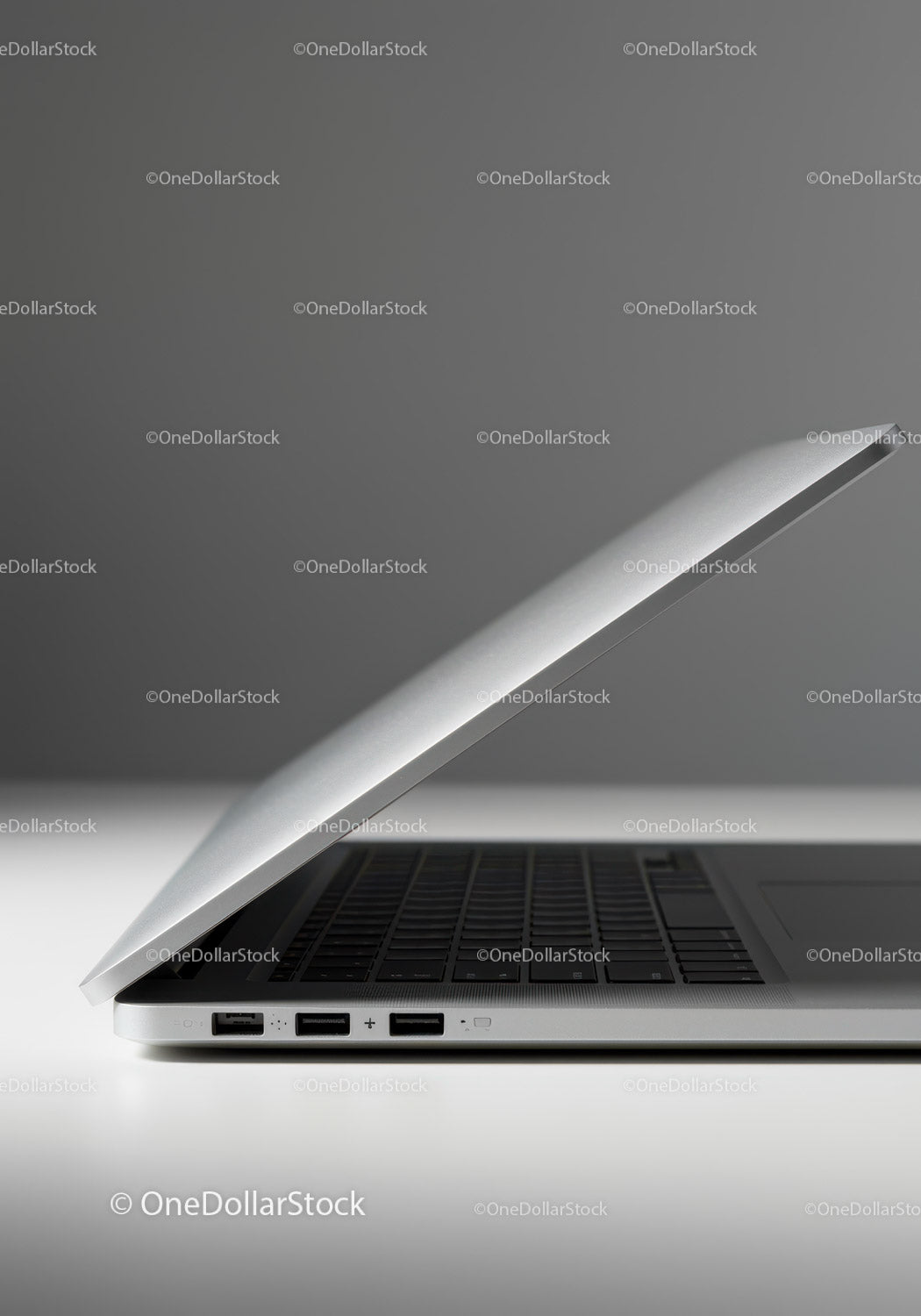 Silver Laptop on White Surface with Gray Background