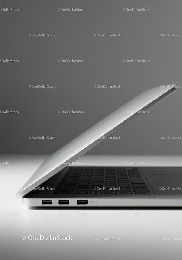 Silver Laptop on White Surface with Gray Background
