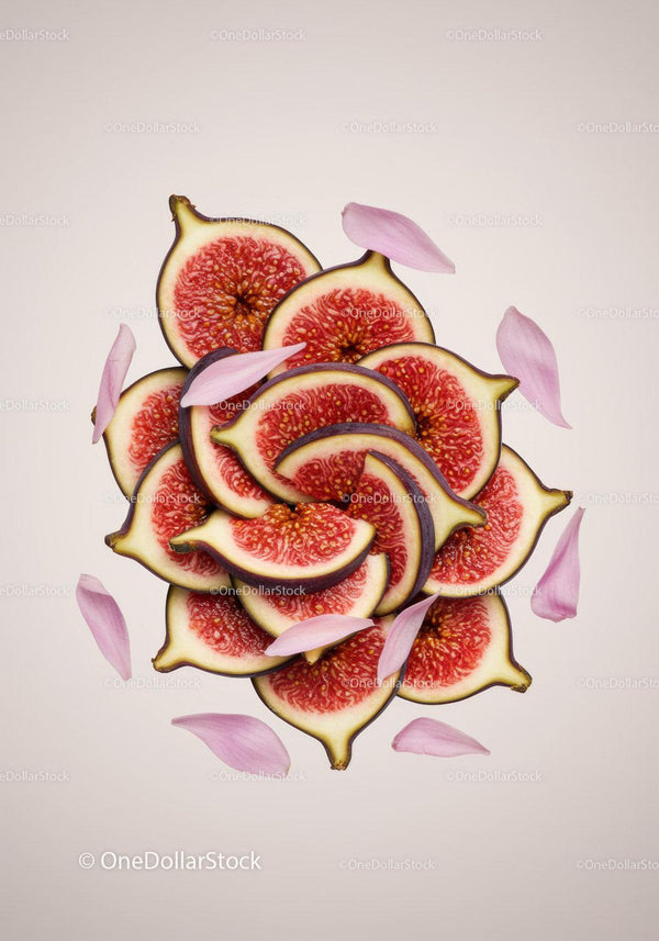 Freshly sliced figs with scattered pink petals