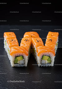 Fresh salmon avocado sushi rolls arranged in letter W
