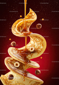 Golden pancakes spiraling with syrup and scattered hazelnuts