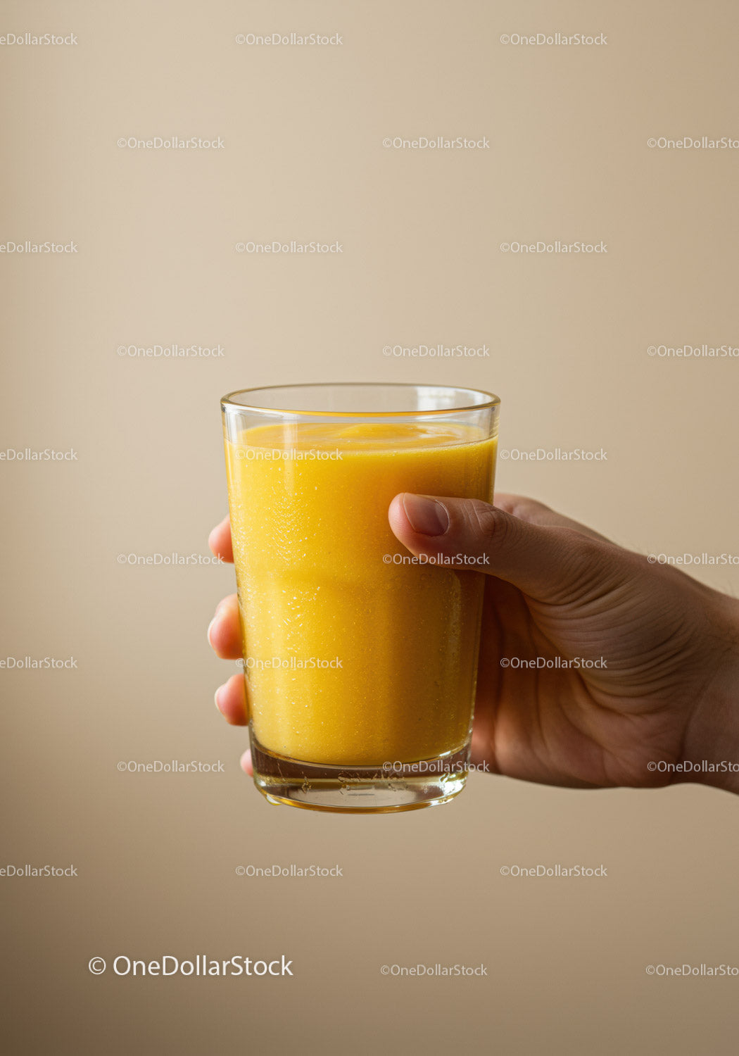 Hand Holding Glass of Fresh Mango Smoothie