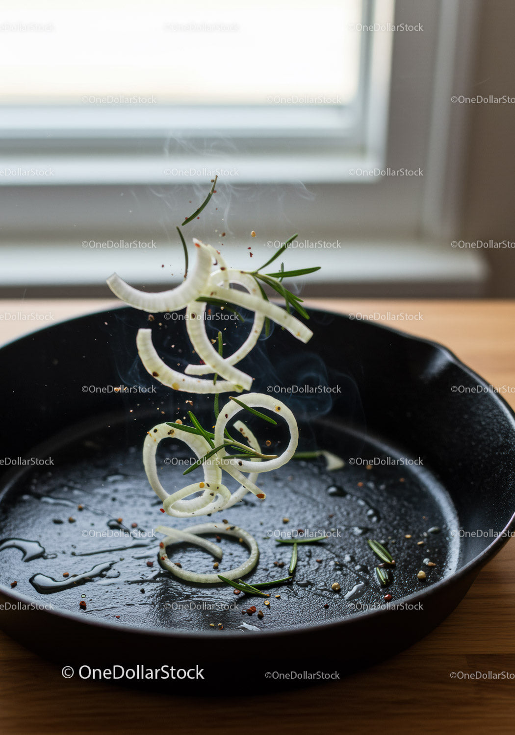 Fresh onion rings and rosemary tossed in hot skillet