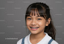 Smiling Girl with Braces and Bright Eyes on Grey Background