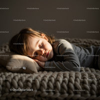 Peaceful toddler sleeping on cozy knitted blanket