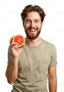 Happy Man with Curly Hair Holding a Bright Red Grapefruit